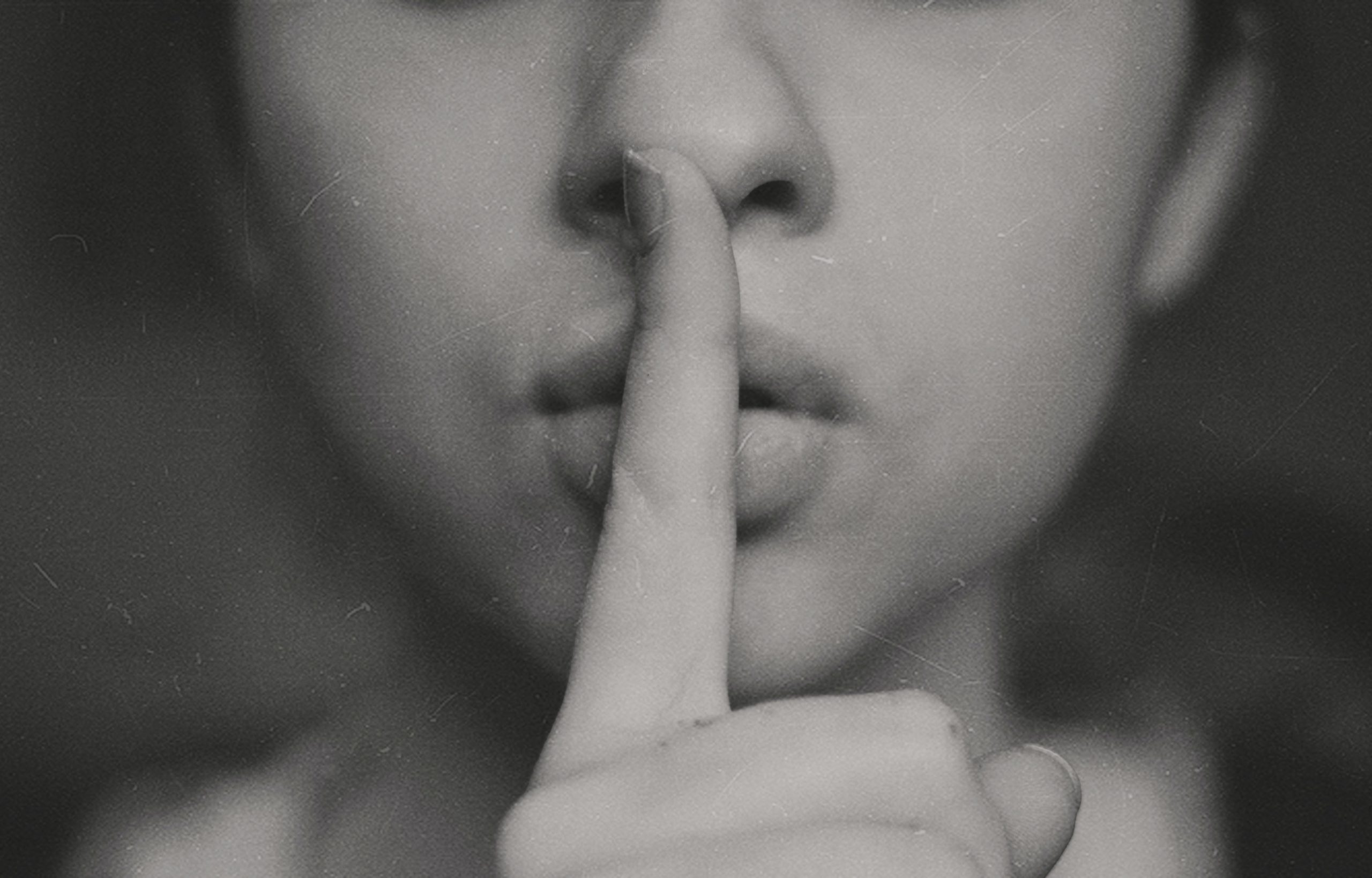 Person holding finger to lips