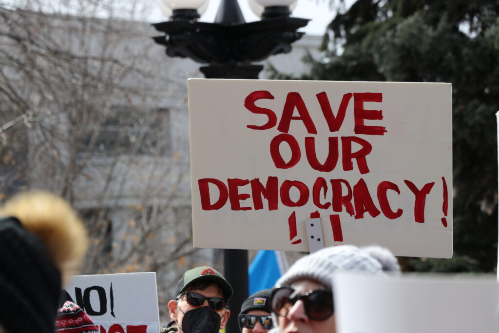 protestors with save our democracy sign